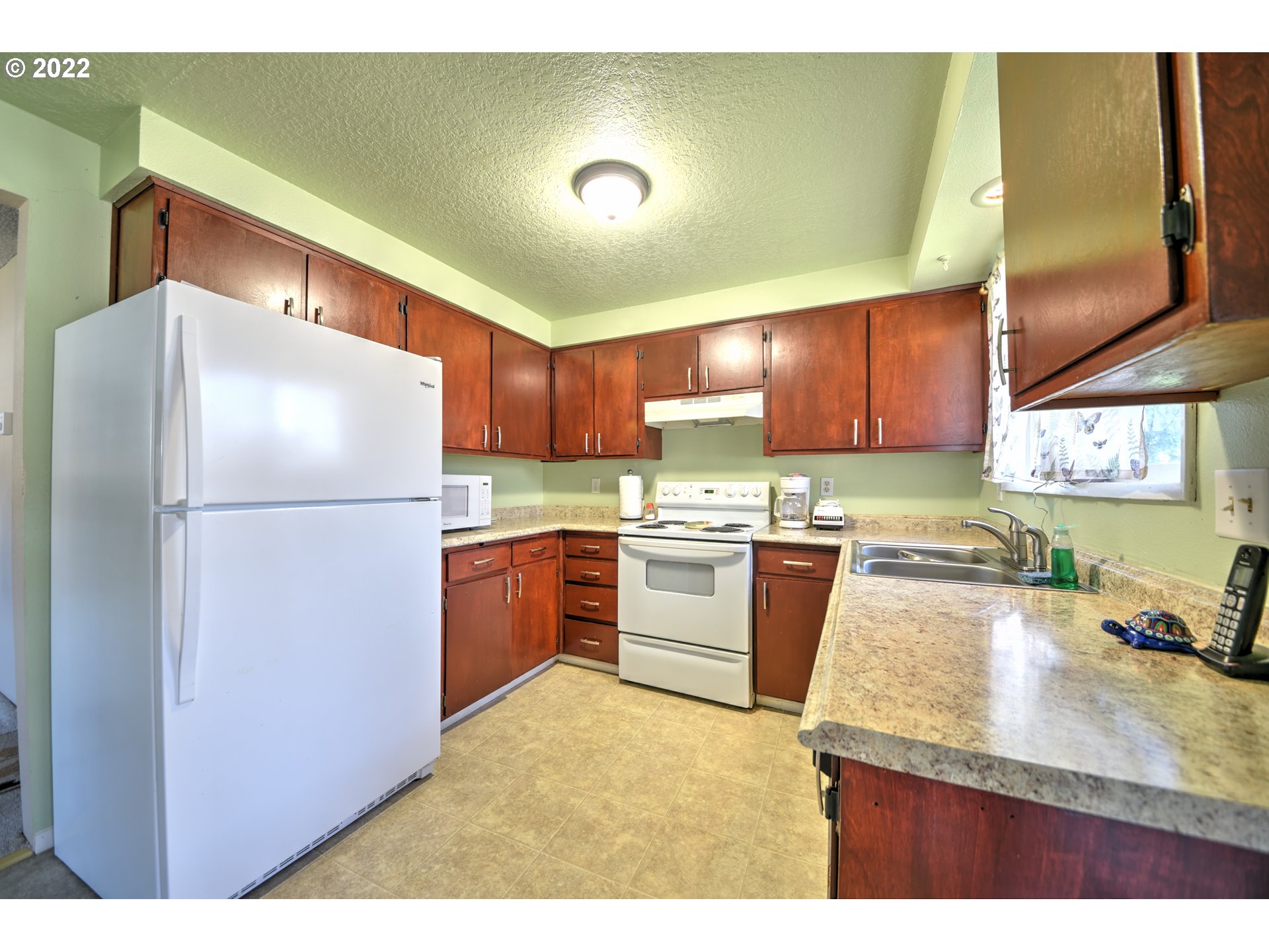 212 72nd Street Springfield, OR 97478 - Photo 7 of 21 a kitchen with granite countertop a refrigerator a sink a stove a dining table and chairs