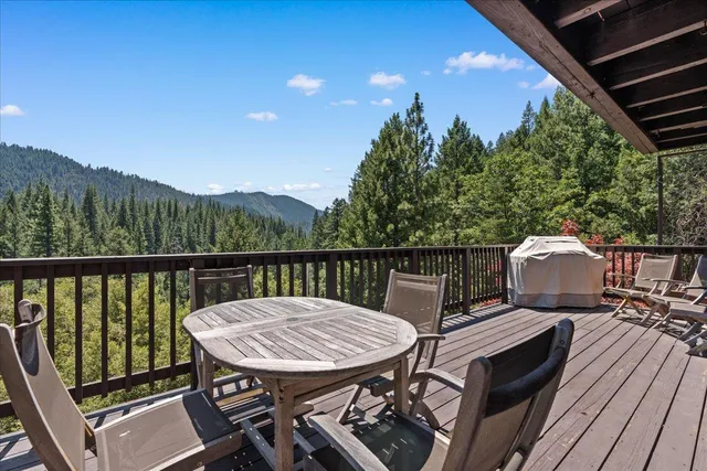 a view of a balcony with a table and chairs with wooden floor and fence