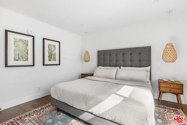 a living room with stainless steel appliances furniture a flat screen tv and kitchen view