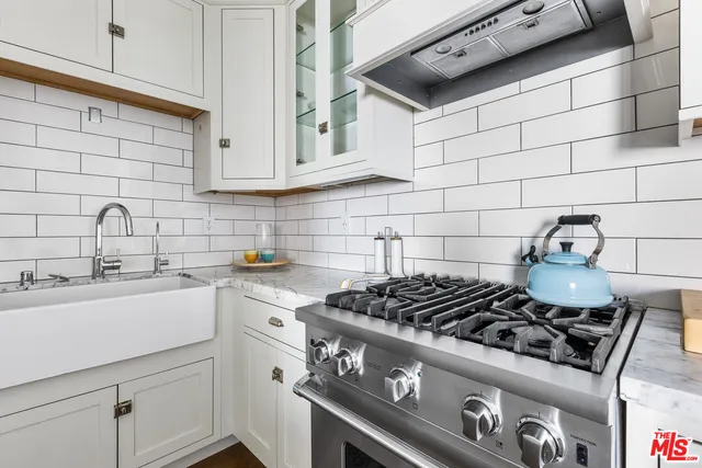 a kitchen with white cabinets and white appliances