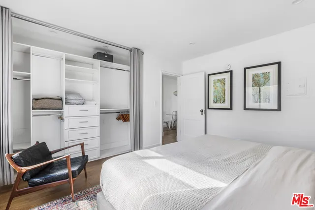 a bedroom with a bed and a painting on the wall