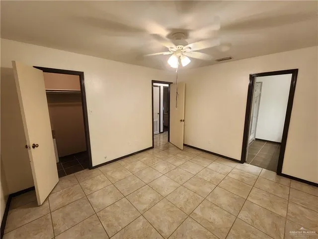 an empty room with fan and entrance