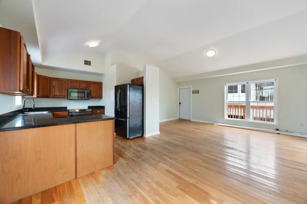 a large kitchen with stainless steel appliances granite countertop a refrigerator and a stove top oven