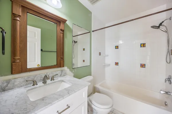 a bathroom with a granite countertop sink toilet and shower