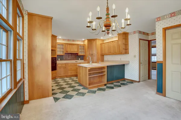 a room with kitchen island stainless steel appliances a sink and a window