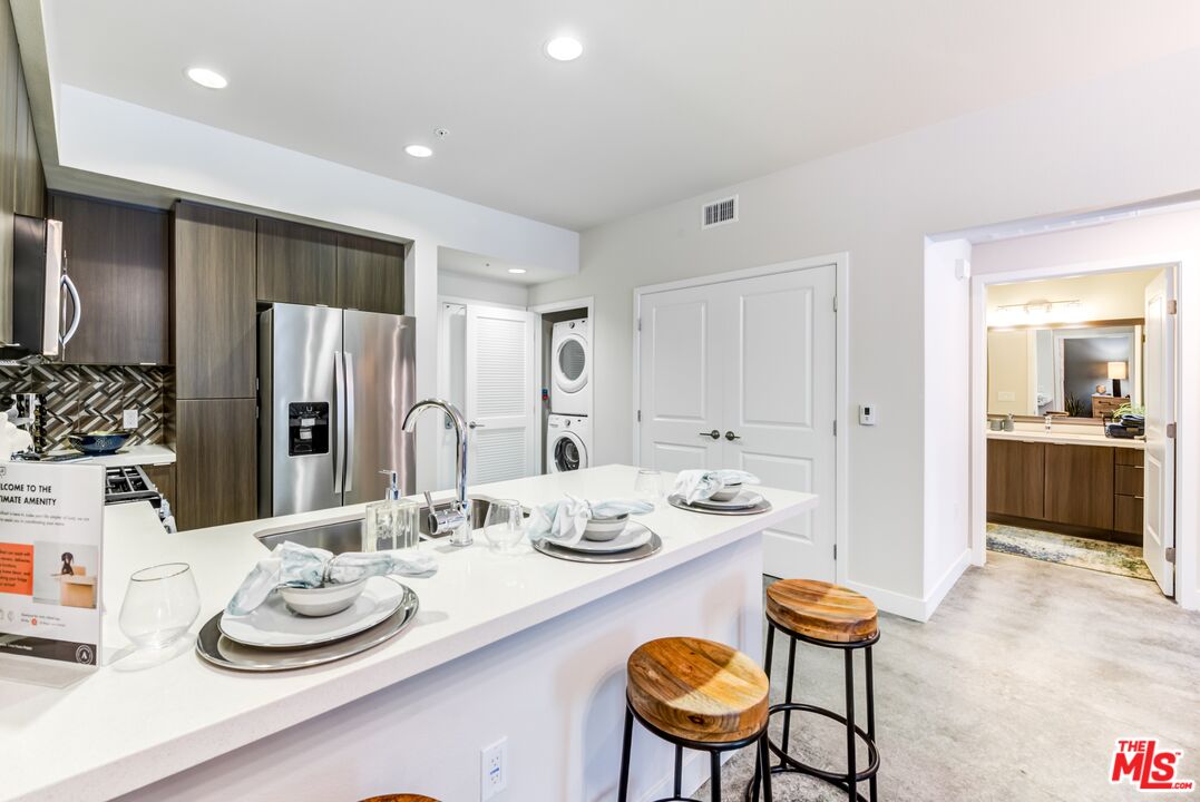 7290 Edinger Avenue, Unit 4038 Huntington Beach, CA 92647 - Photo 5 of 24 a dining room with stainless steel appliances kitchen island granite countertop a table and chairs