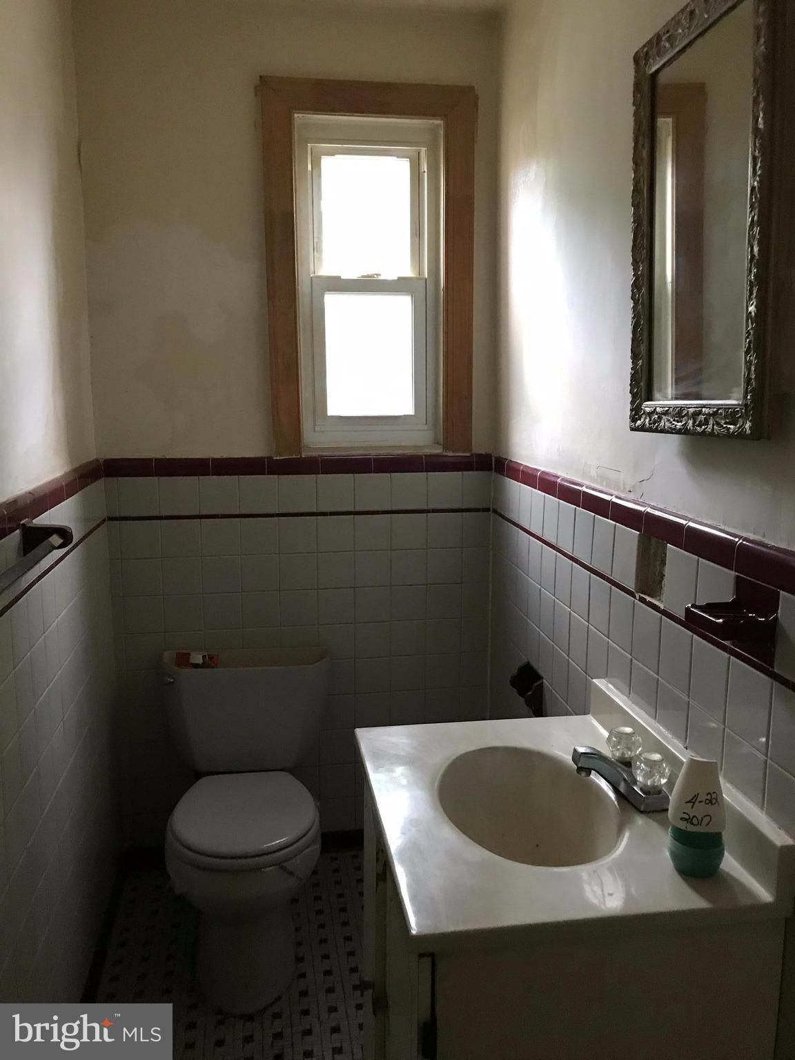 5051 Sargent Road Northeast Washington, DC 20017 - Photo 8 of 11 a bathroom with a toilet a sink and mirror