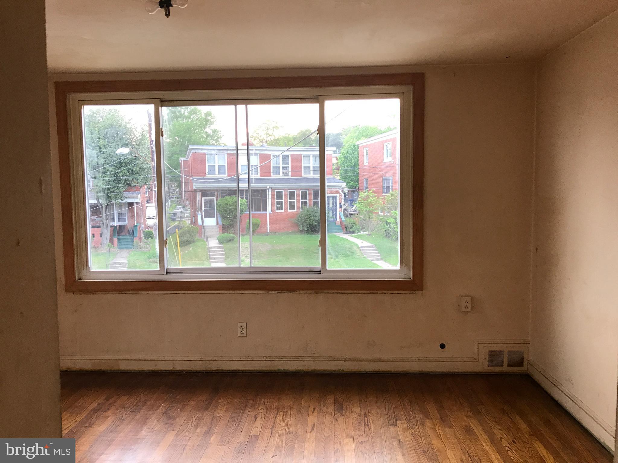 5051 Sargent Road Northeast Washington, DC 20017 - Photo 9 of 11 an empty room with wooden floor and a window