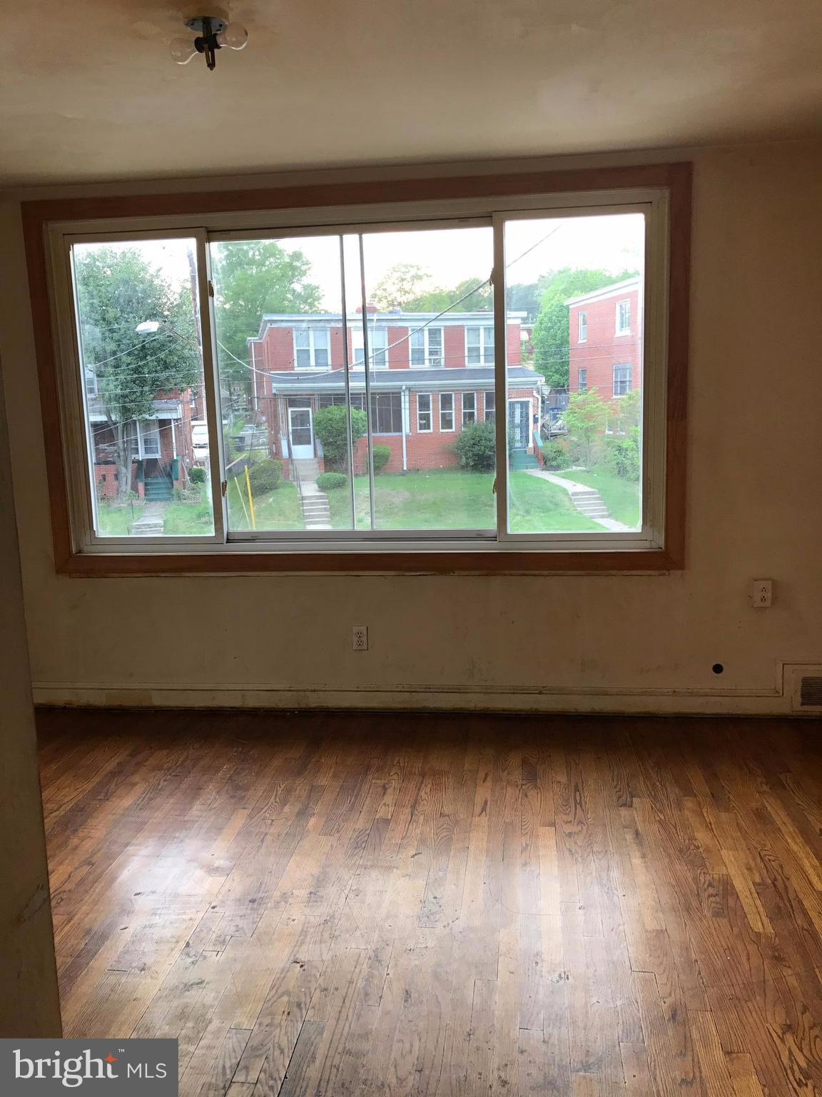 5051 Sargent Road Northeast Washington, DC 20017 - Photo 10 of 11 an empty room with wooden floor and windows