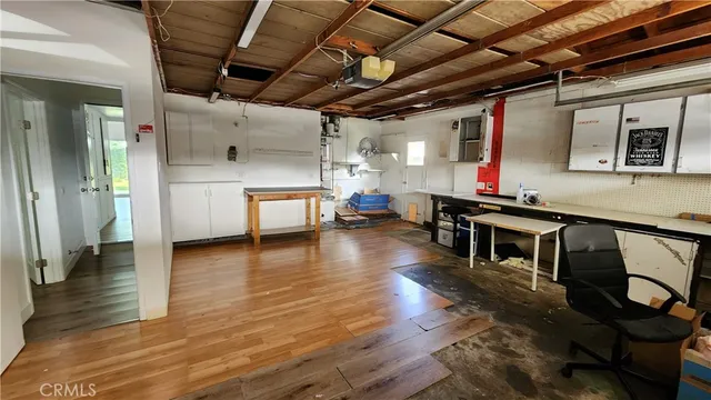 a view of a room with wooden floor and a kitchen