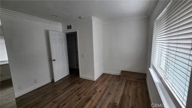 a view of a livingroom with wooden floor and a fireplace