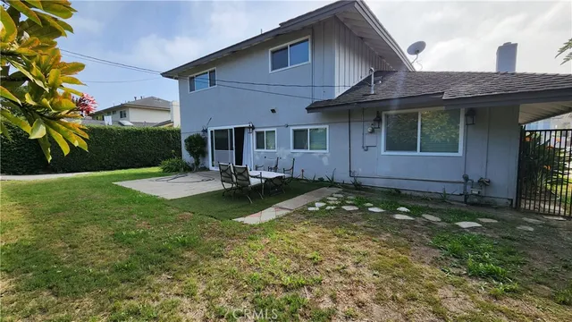 a view of a house with a yard patio and a fountain