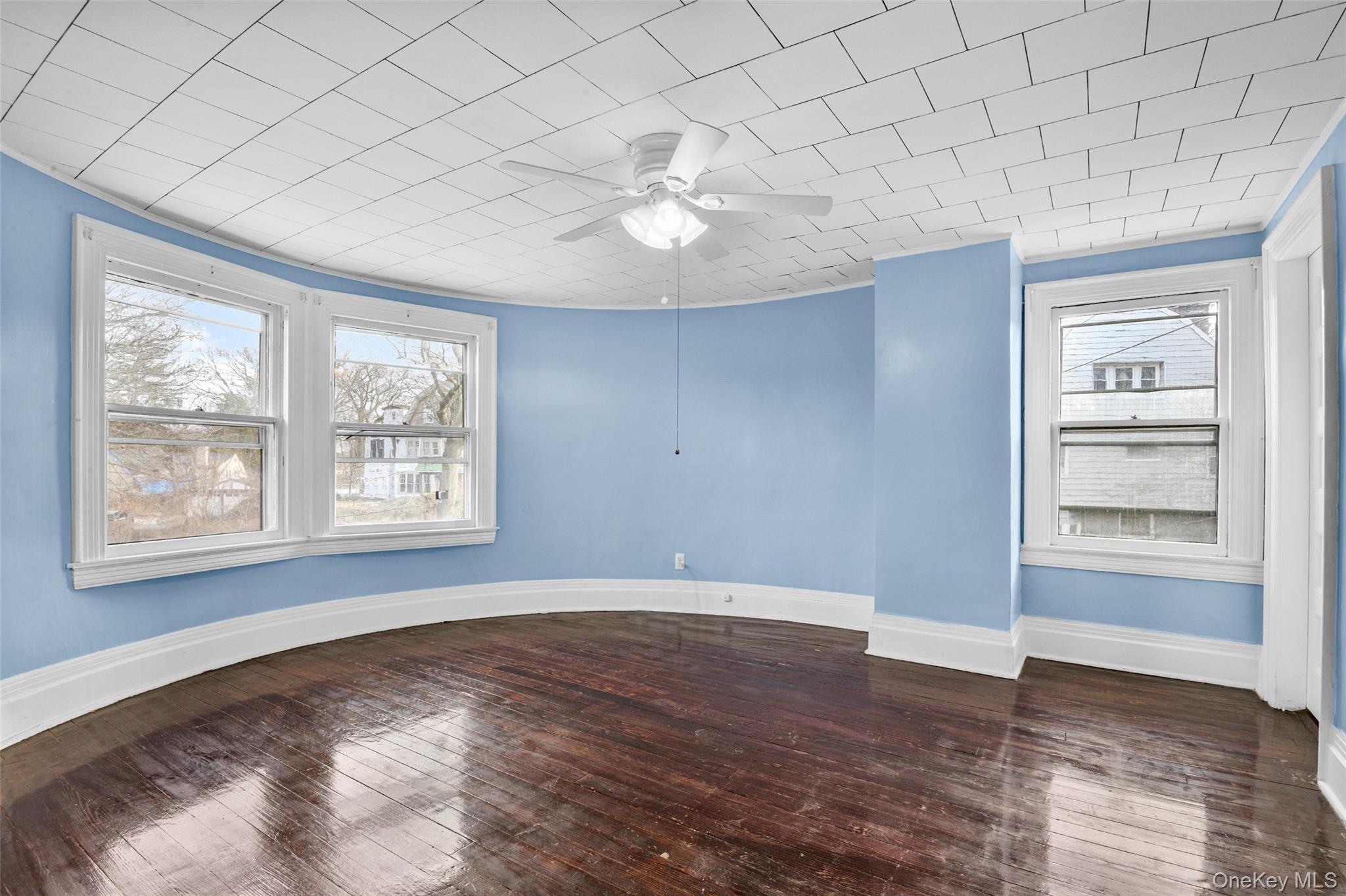 8 The Serpentine New Rochelle, NY 10801 - Photo 22 of 48 an empty room with wooden floor chandelier fan and windows