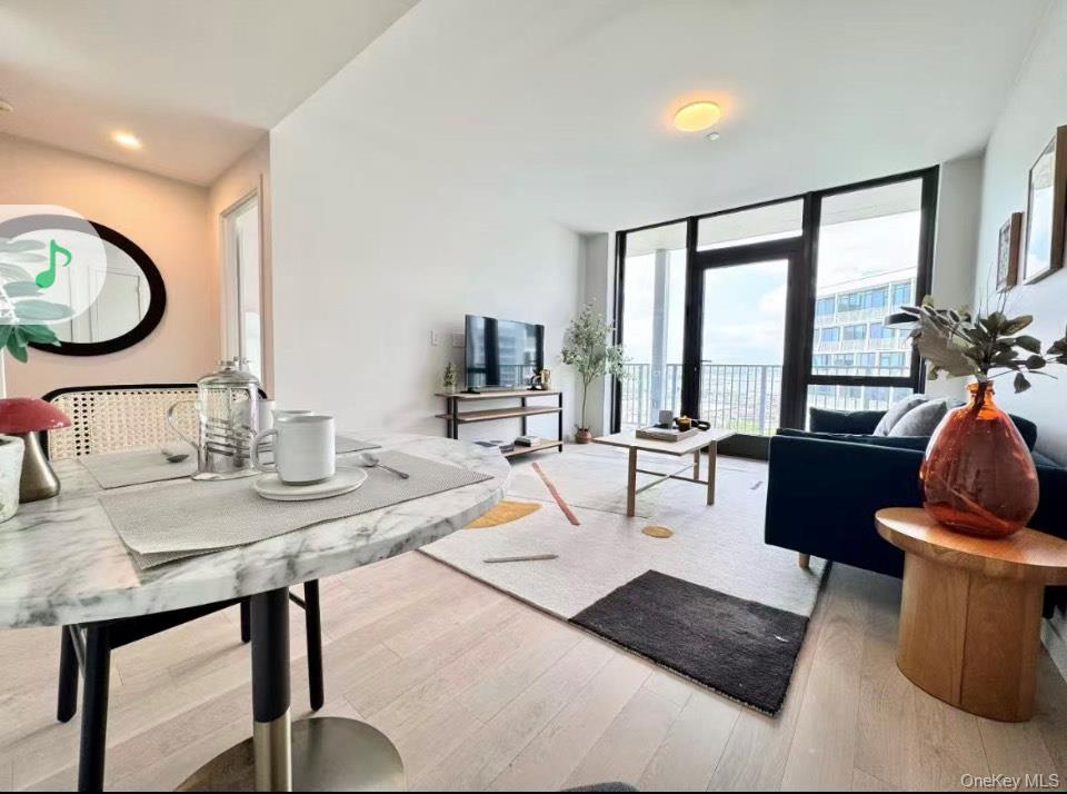 131-02 40th Road, Unit 17I Queens, NY 11354 - Photo 2 of 8 a living room with furniture and a large window