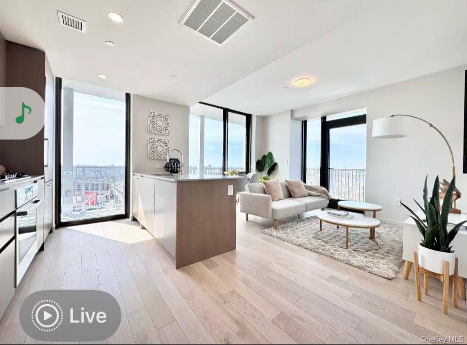 131-02 40th Road, Unit 17I Queens, NY 11354 - Photo 3 of 8 a living room with furniture and large windows