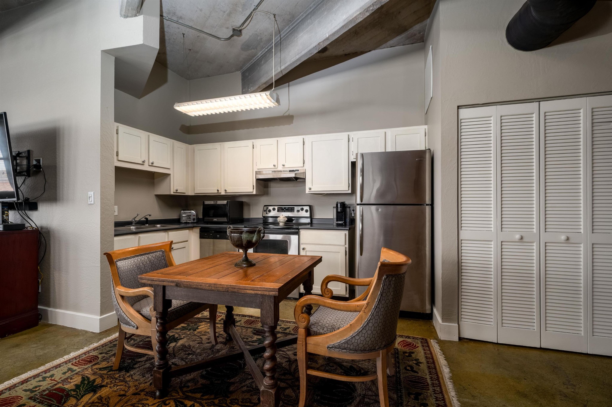 408 South Front Street, Unit 412 Memphis, TN 38103 - Photo 3 of 21 a kitchen with stainless steel appliances granite countertop a dining table chairs refrigerator and sink