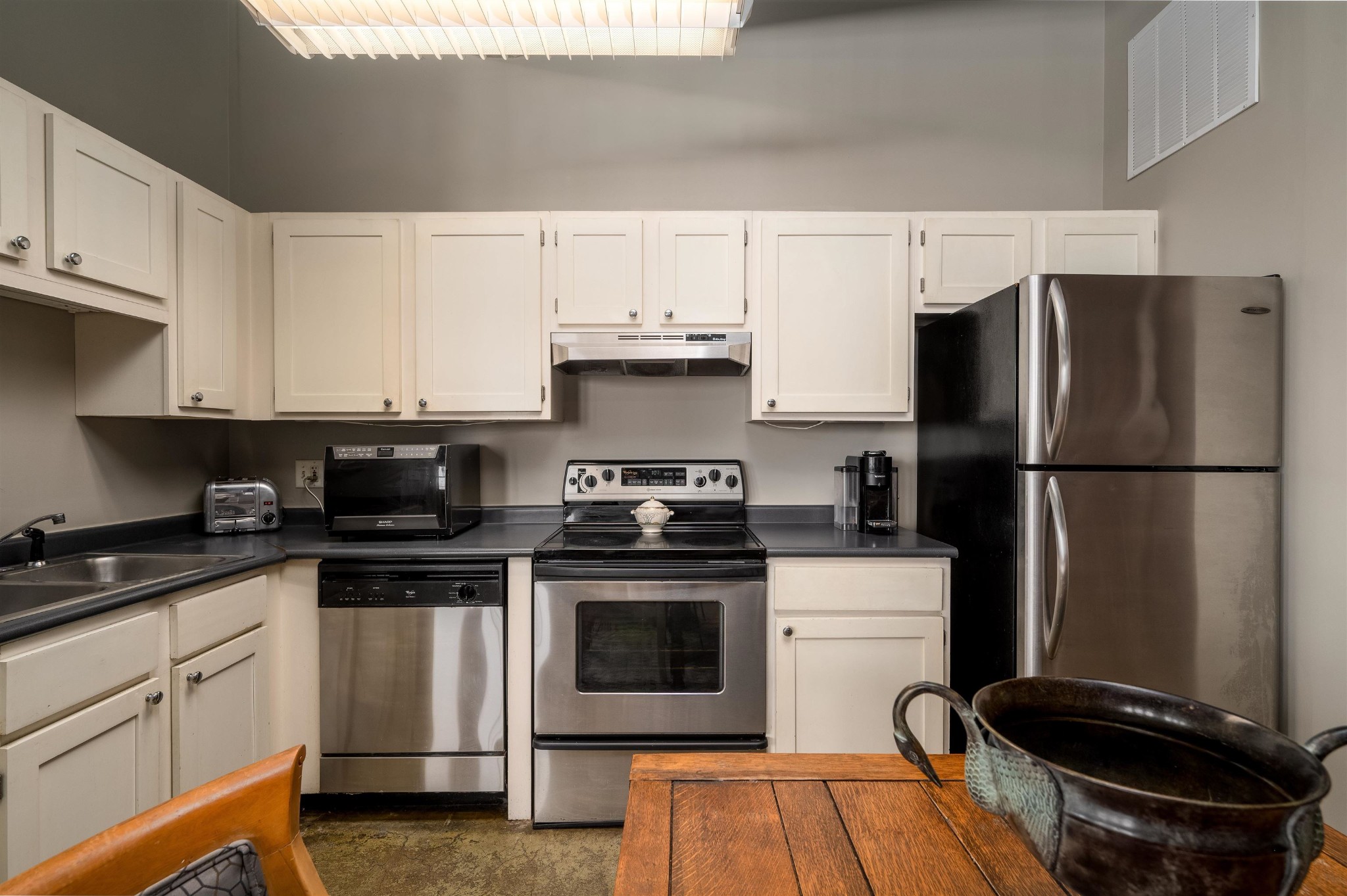 408 South Front Street, Unit 412 Memphis, TN 38103 - Photo 4 of 21 a kitchen with a refrigerator stove and white cabinets