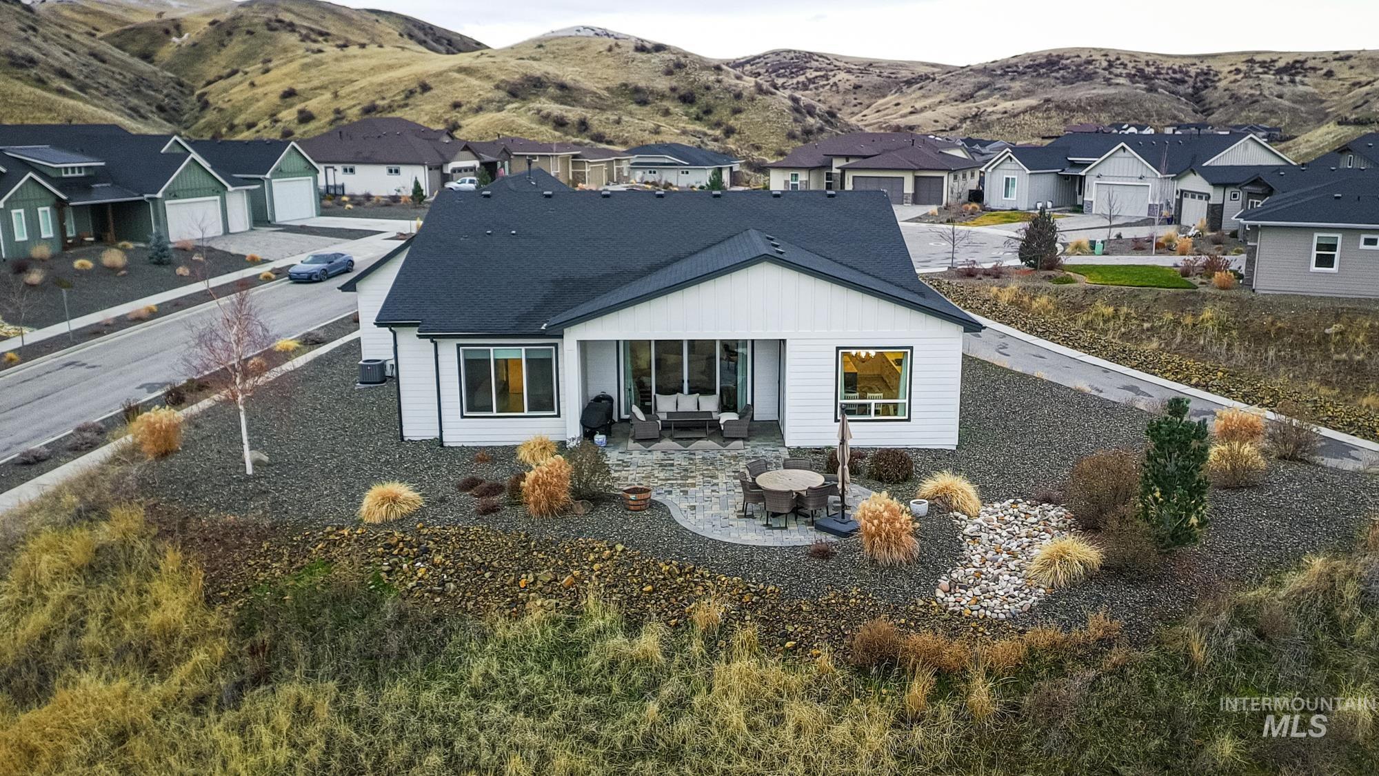 18357 North Burnt Car Way Boise, ID 83714 - Photo 3 of 48 Back of house with a mountain view, a patio, and a residential view