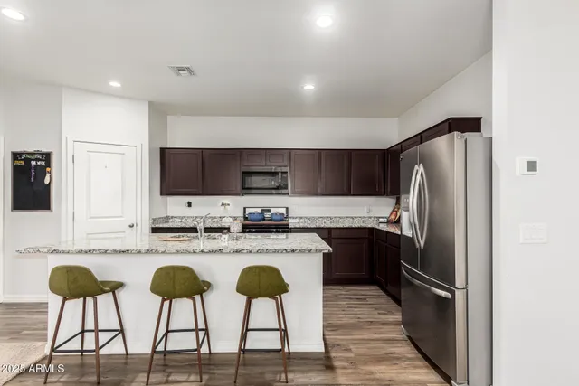 a kitchen with stainless steel appliances granite countertop a stove a sink and a refrigerator