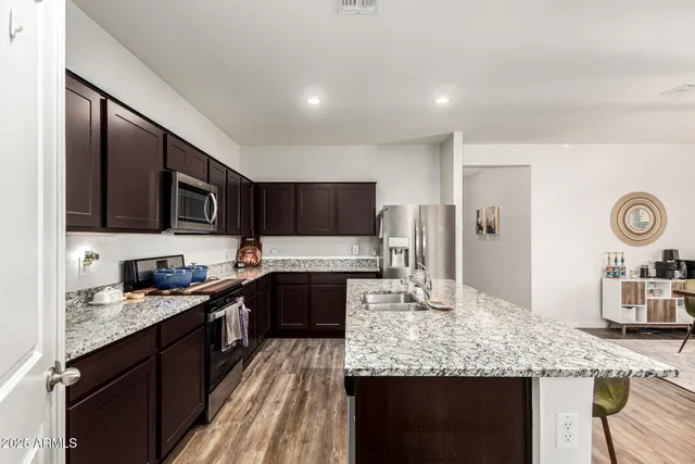 a large kitchen with granite countertop stainless steel appliances and a counter space