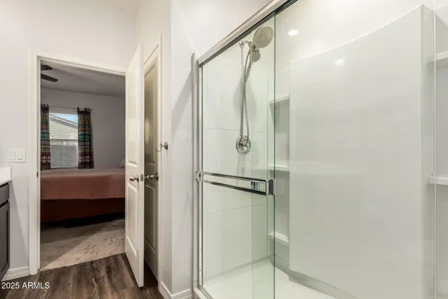 a bathroom with a glass door shower and a sink