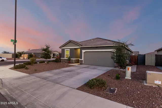 a front view of a house with a garden and parking