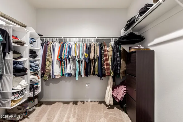 a view of walk in closet with clothes and shoes