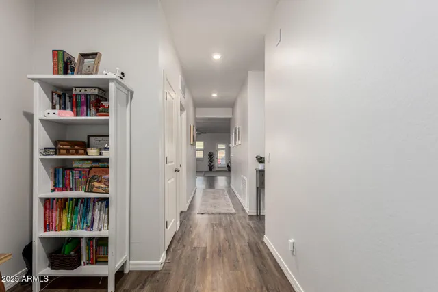 a view of a hallway with wooden floor and closet