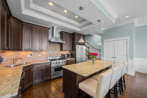a kitchen with stainless steel appliances granite countertop a sink a stove and cabinets