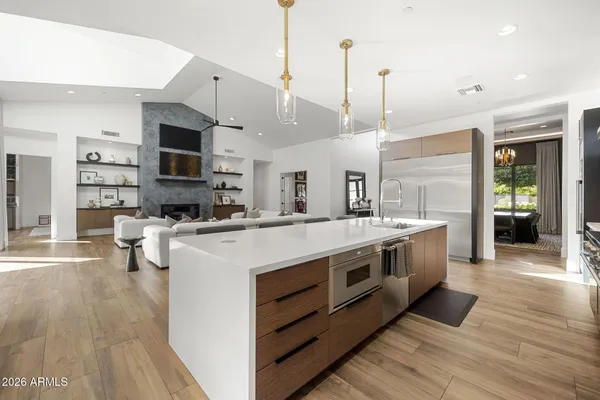 a large kitchen with stainless steel appliances granite countertop a stove and a wooden floors