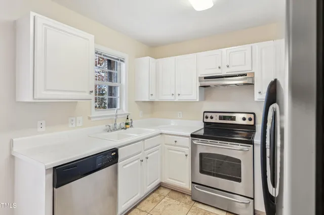 a kitchen with cabinets stainless steel appliances a sink and a window
