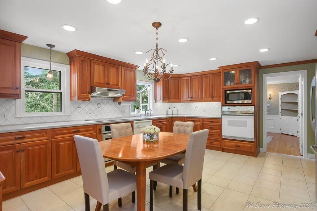 8 Curtis Road Boxford, MA 01921 - Photo 7 of 42 a kitchen with stainless steel appliances granite countertop a table chairs sink refrigerator and microwave