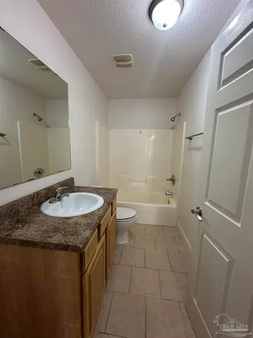 a bathroom with a granite countertop sink a toilet and a shower