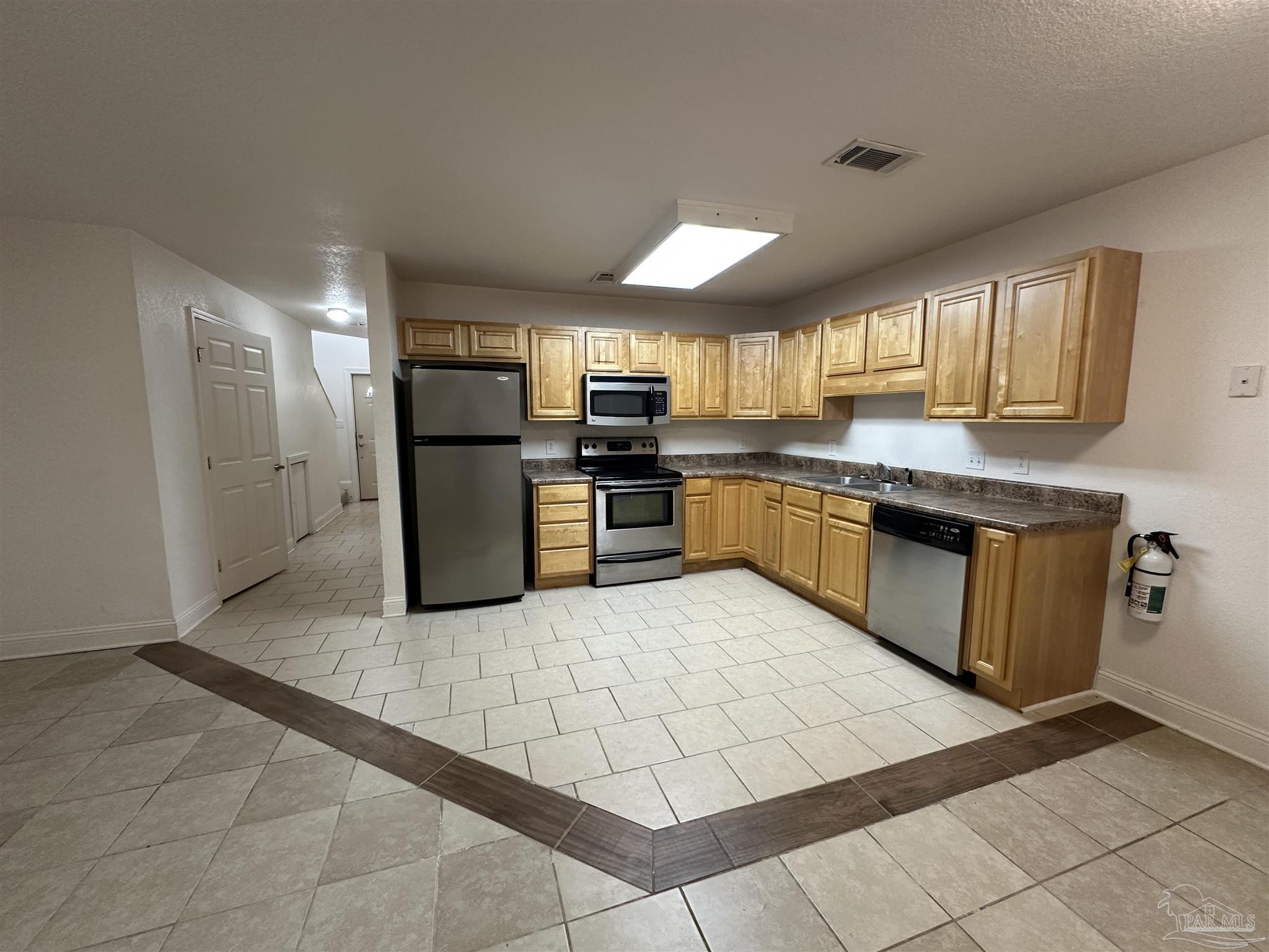 6250 Hamilton Bridge Road, Unit B Milton, FL 32570 - Photo 2 of 16 a kitchen with stainless steel appliances granite countertop a stove top oven a sink a counter top space and cabinets