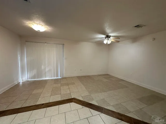an empty room with a ceiling fan and chandelier fan
