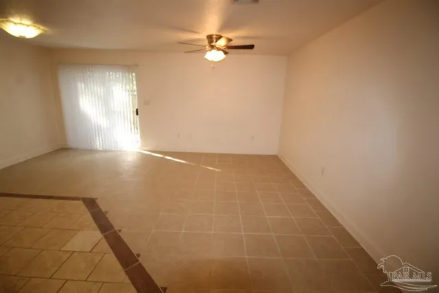an empty room with windows and fan
