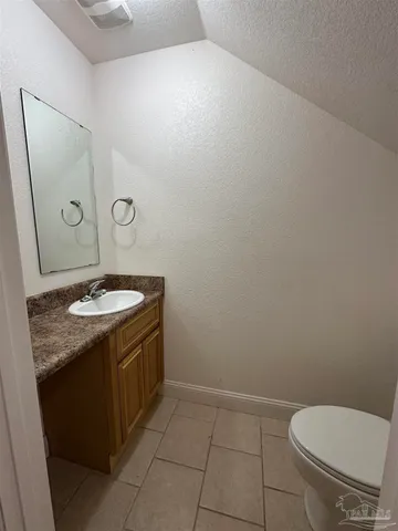 a bathroom with a granite countertop sink toilet and a mirror