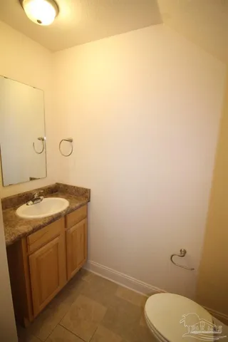 a bathroom with a granite countertop toilet and a sink