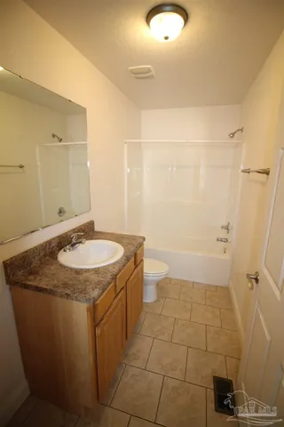 a bathroom with a granite countertop sink a toilet and a mirror