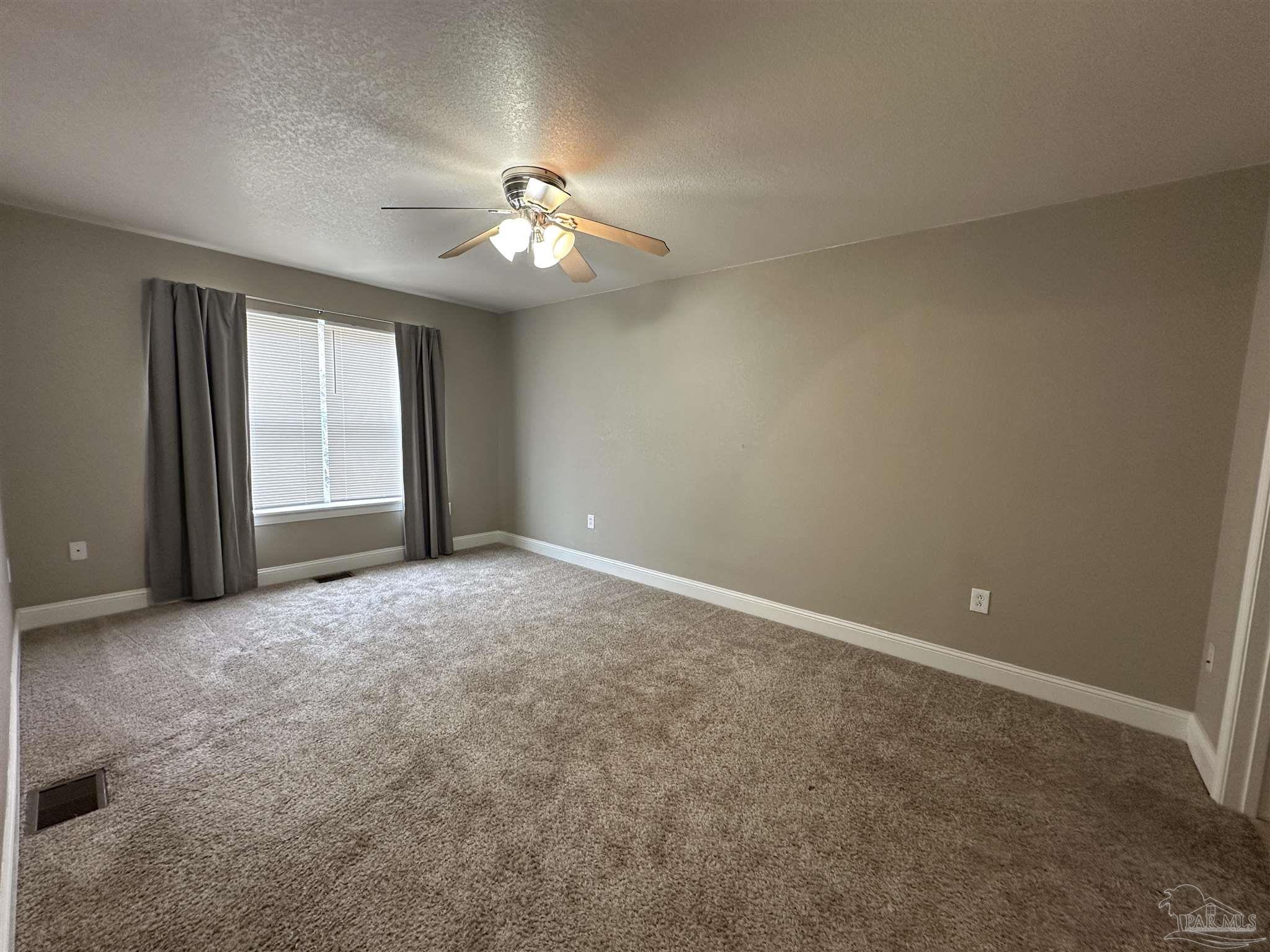 6250 Hamilton Bridge Road, Unit B Milton, FL 32570 - Photo 10 of 16 an empty room with windows and fan