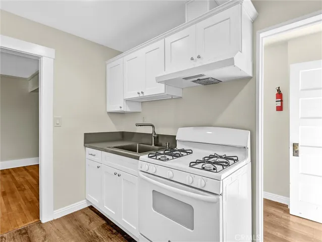 a kitchen with white cabinets and appliances