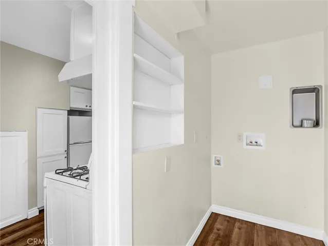 a walk in closet with wooden floor