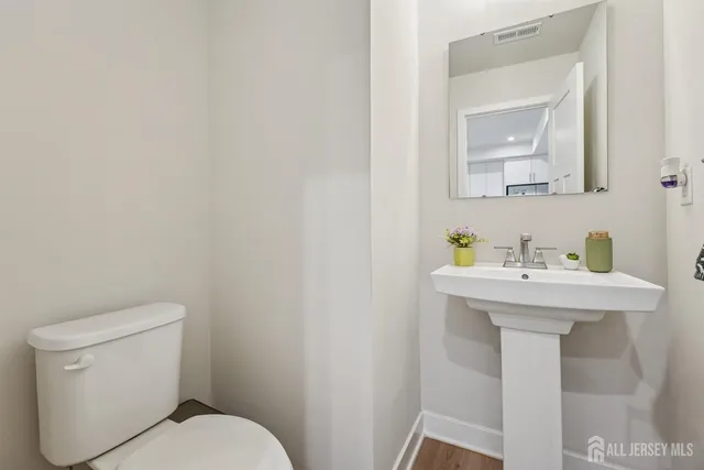 a bathroom with a sink a toilet and mirror