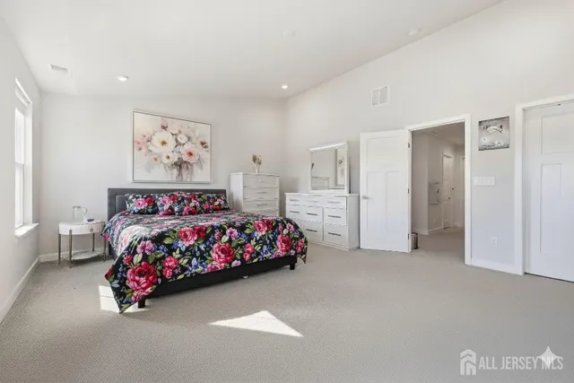 a bedroom with a bed and a painting on the wall