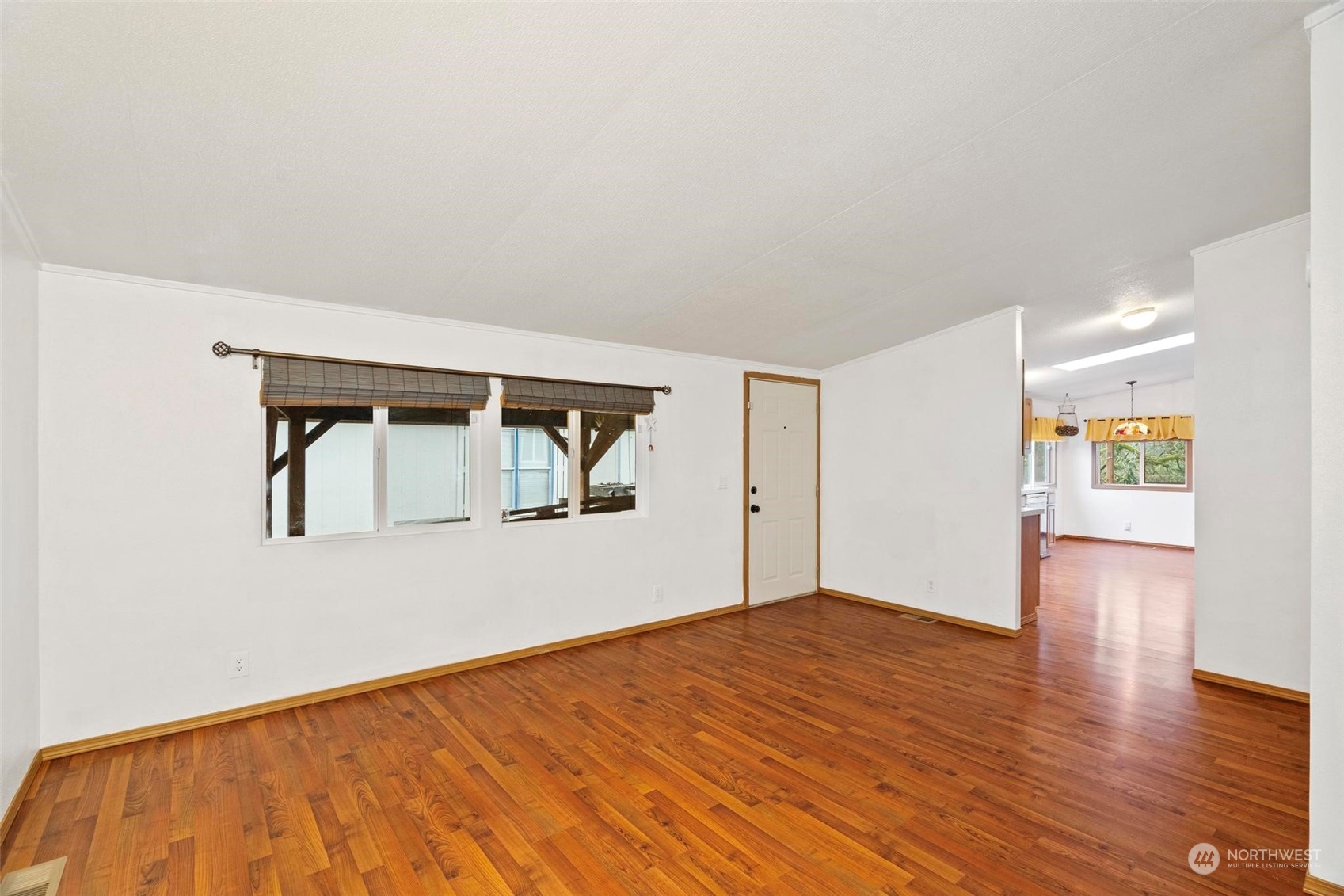 10239 185th Avenue Southwest, Unit 54 Rochester, WA 98579 - Photo 6 of 24 a view of an empty room with wooden floor and a window