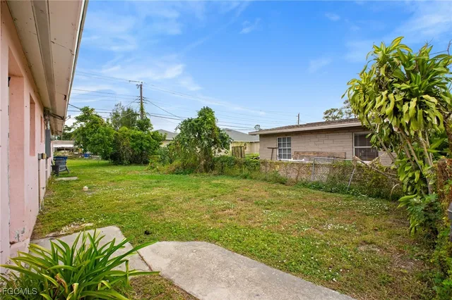 a backyard of a house with plants and large trees