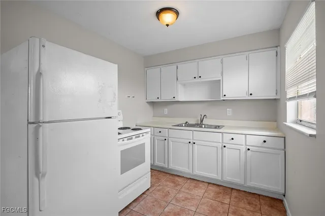a kitchen with white cabinets and white appliances