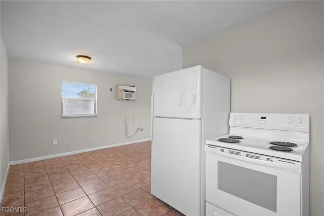 a white refrigerator freezer and a stove sitting inside of a kitchen