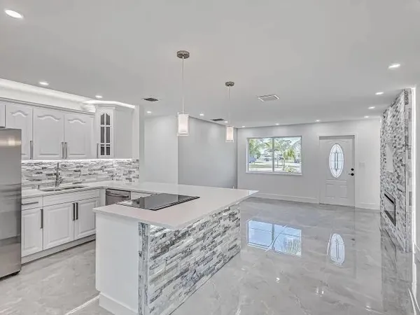 a kitchen with stainless steel appliances granite countertop a sink stove and refrigerator