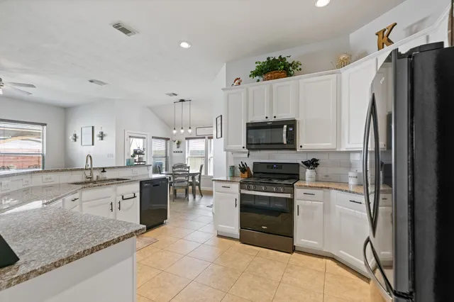 a kitchen with granite countertop a sink stove and refrigerator